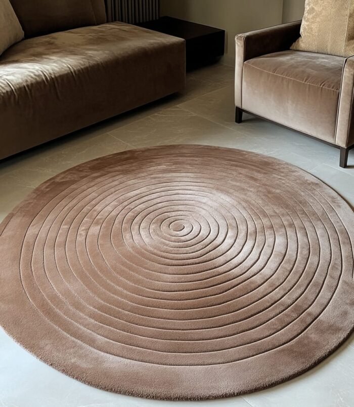 Handmade round beige rug with concentric circle design, perfect for modern and minimalist interiors.