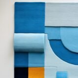 Modern geometric rectangular rug in shades of blue with bold yellow accent for contemporary interiors.