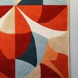 Modern abstract geometric area rug in bold red and neutral tones, ideal for stylish and contemporary interiors.