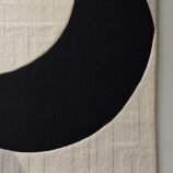 Minimalist crescent abstract rug with bold black crescent on a textured ivory backdrop for modern interiors.