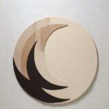 Circular crescent moon rug with a minimalist design in beige and black tones, perfect for modern decor.