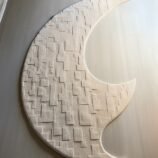 Crescent moon rug with geometric textures in neutral beige, designed for contemporary and minimalist interiors.