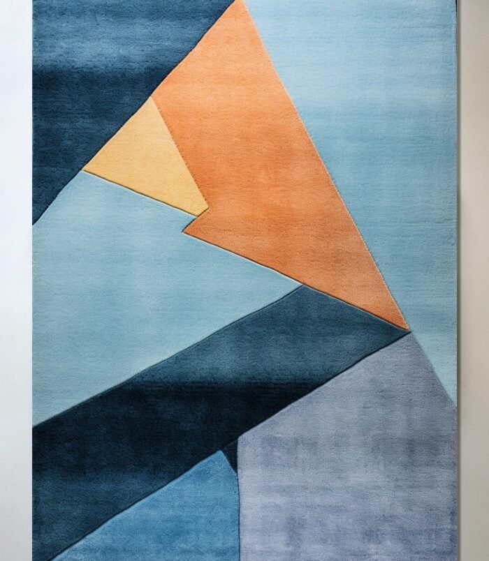 Abstract geometric rug with bold blue, orange, and yellow tones in a modern hand-tufted design.