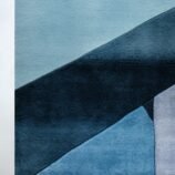 Abstract geometric rug with bold blue, orange, and yellow tones in a modern hand-tufted design.