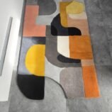 Abstract geometric runner rug in yellow, gray, and orange tones, ideal for kitchens and hallways.
