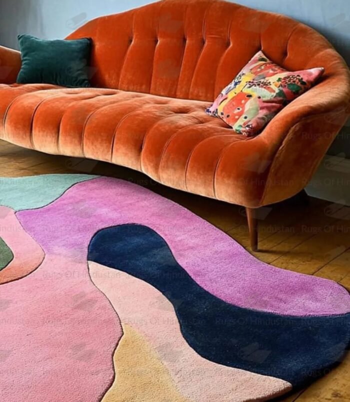 Hand-tufted multicolor wool rug in irregular shape under retro orange sofa in vibrant living room