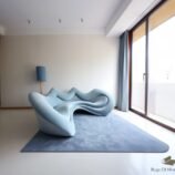 Minimalist hand-tufted solid blue wool rug under sculptural blue sofa in contemporary interior