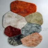Irregular high-pile wool rug with organic color blocks in shag texture on modern white floor