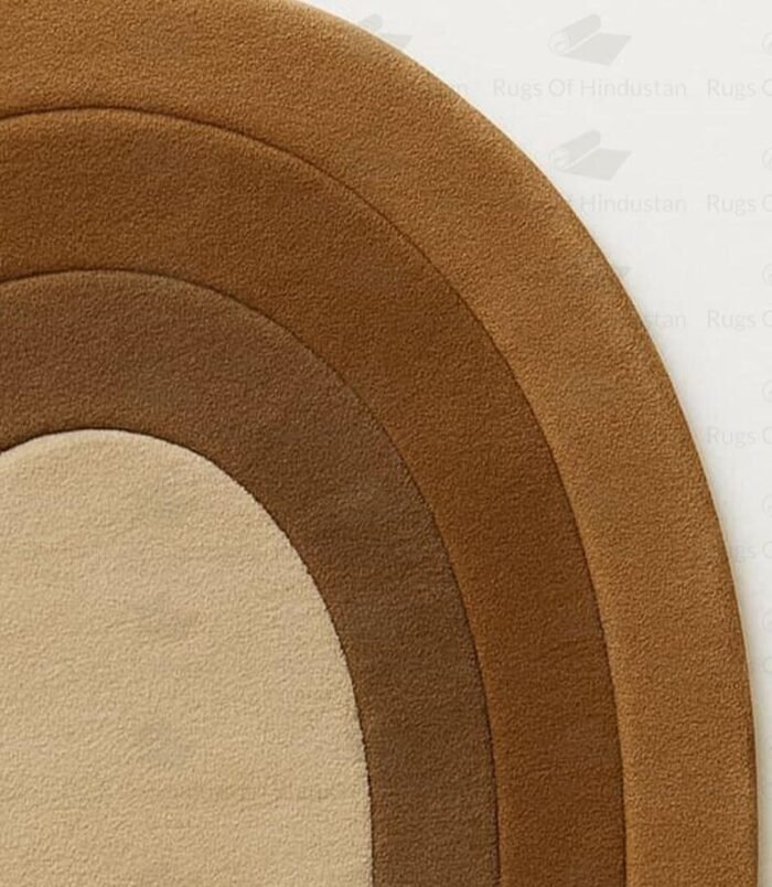 Concentric hand-tufted oval wool rug in gradient brown tones on white background