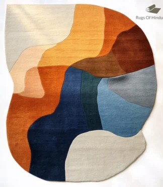 Modern abstract area rug in warm earth tones of orange, blue, and beige, handcrafted for modern interiors.