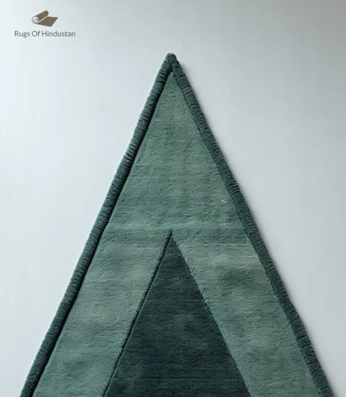 Handmade triangle wool rug in soft green with a minimalist geometric design, ideal for modern homes.