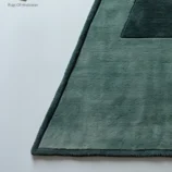 Handmade triangle wool rug in soft green with a minimalist geometric design, ideal for modern homes.