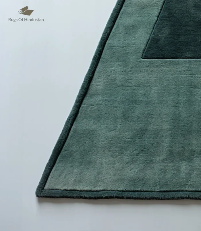 Handmade triangle wool rug in soft green with a minimalist geometric design, ideal for modern homes.