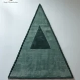 Handmade triangle wool rug in soft green with a minimalist geometric design, ideal for modern homes.