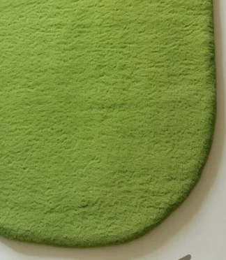 Modern green leaf-shaped rug with minimalist organic design, perfect for eco-friendly interiors.