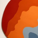 Bold abstract round area rug with vibrant orange, blue, and red hues, perfect for modern interiors.