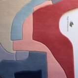 Handmade geometric abstract wool rug with layered design in warm and cool tones, perfect for modern home decor.