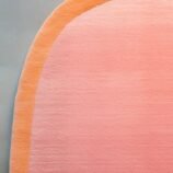 Peach pink oval rug with soft orange border on minimalist background – modern wool carpet