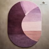 Modern oval abstract rug in shades of purple and pink with a unique artistic design