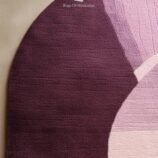 Modern oval abstract rug in shades of purple and pink with a unique artistic design